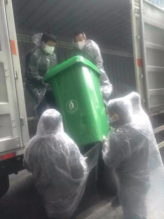 工人们将医疗废物抬上运输车